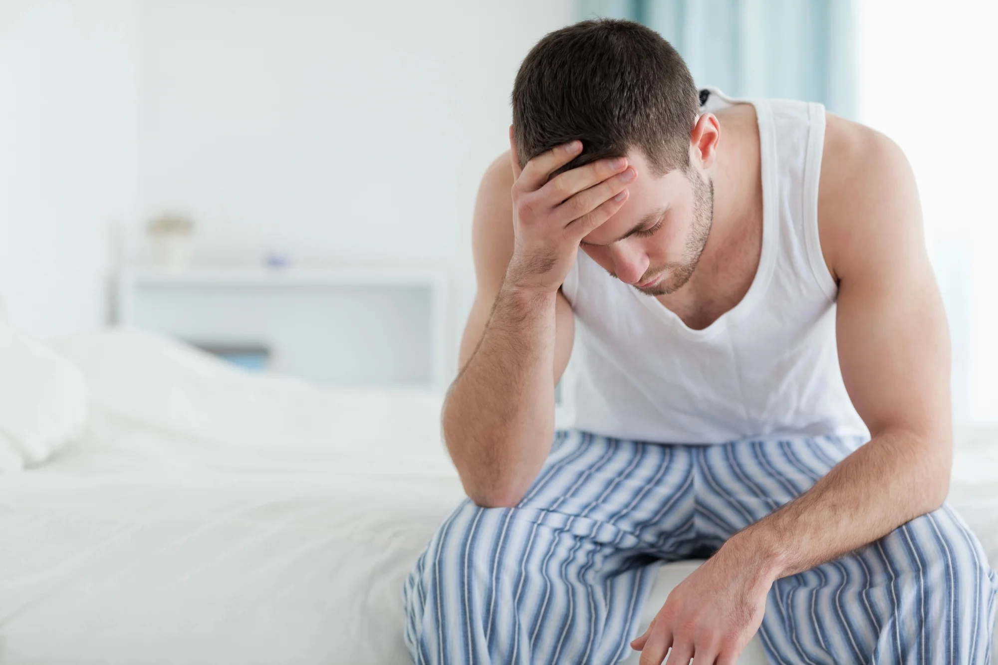 man sitting in bed dealing with paws - post acute withdrawal syndrome