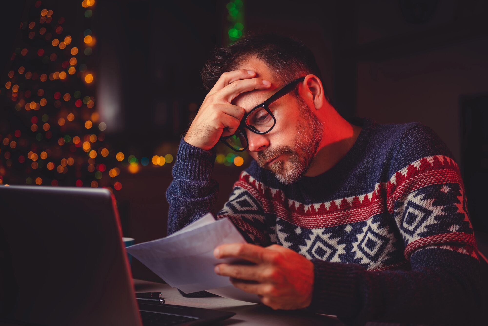 man paying bills dealing with the financial stress of the holdiays