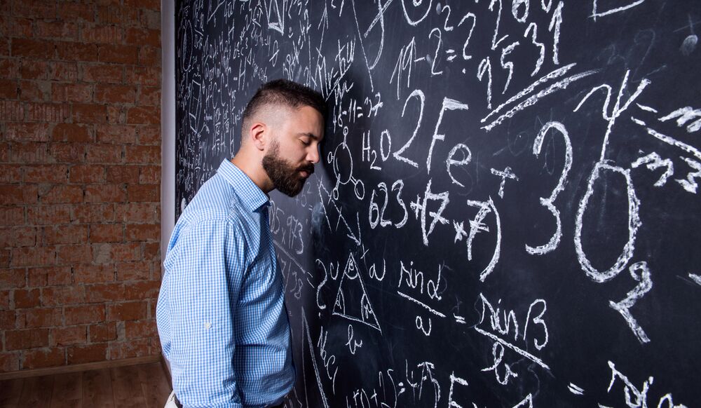 teacher struggling at a blackboard