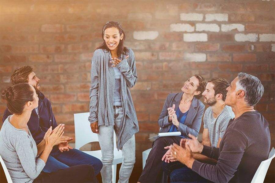 Group therapy session at our addiction rehab near Little Egg Harbor Township New Jersey A woman happy with her addiction treatment plan for alcohol abuse, knowing it won't affect her personal life and profession