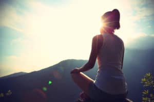 young woman meditating on mountains